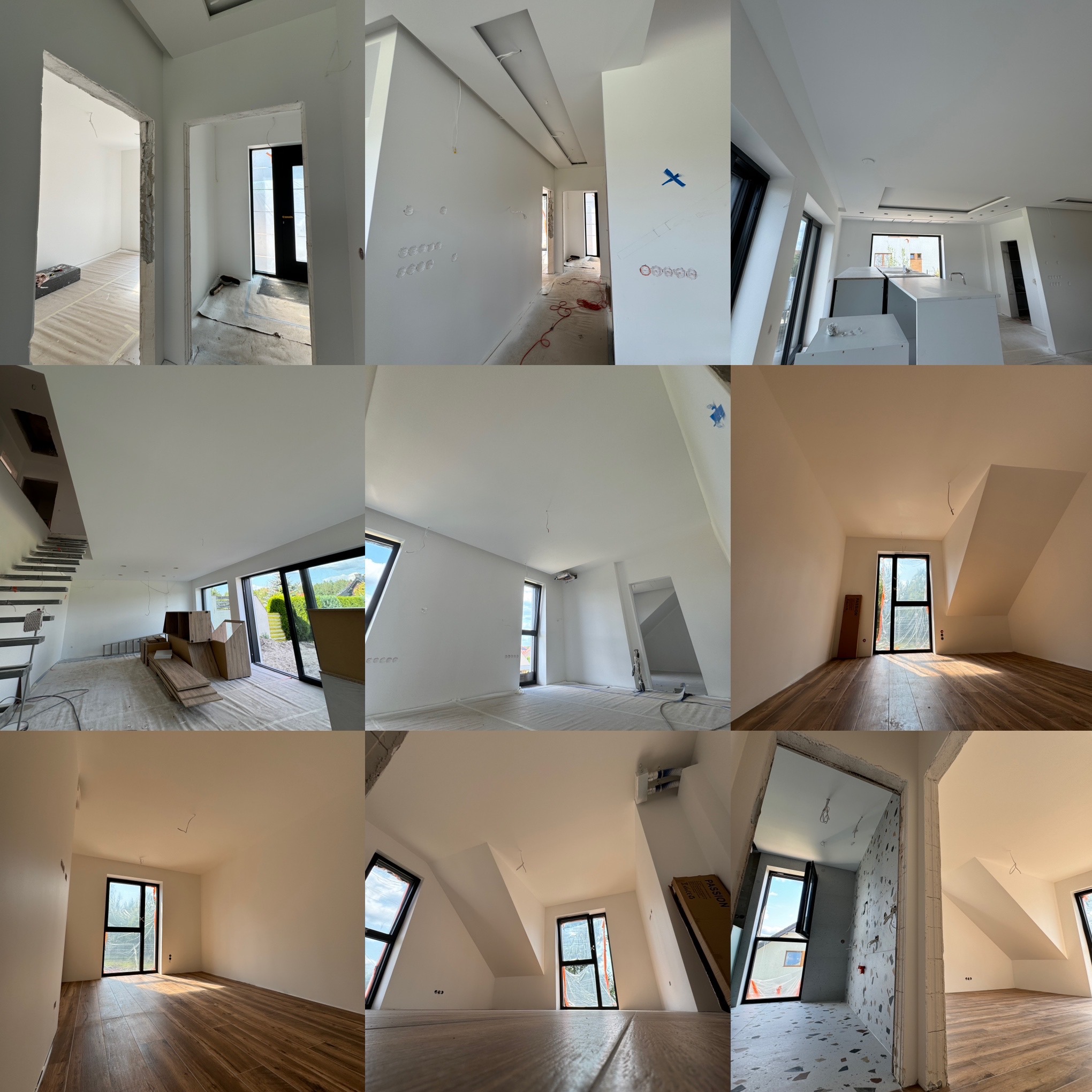 Wnętrze domu w trakcie prac wykończeniowych: świeżo pomalowane białe ściany, widoczne instalacje elektryczne, okna z czarnymi ramami, częściowo zabezpieczona podłoga, w tle schody i elementy...