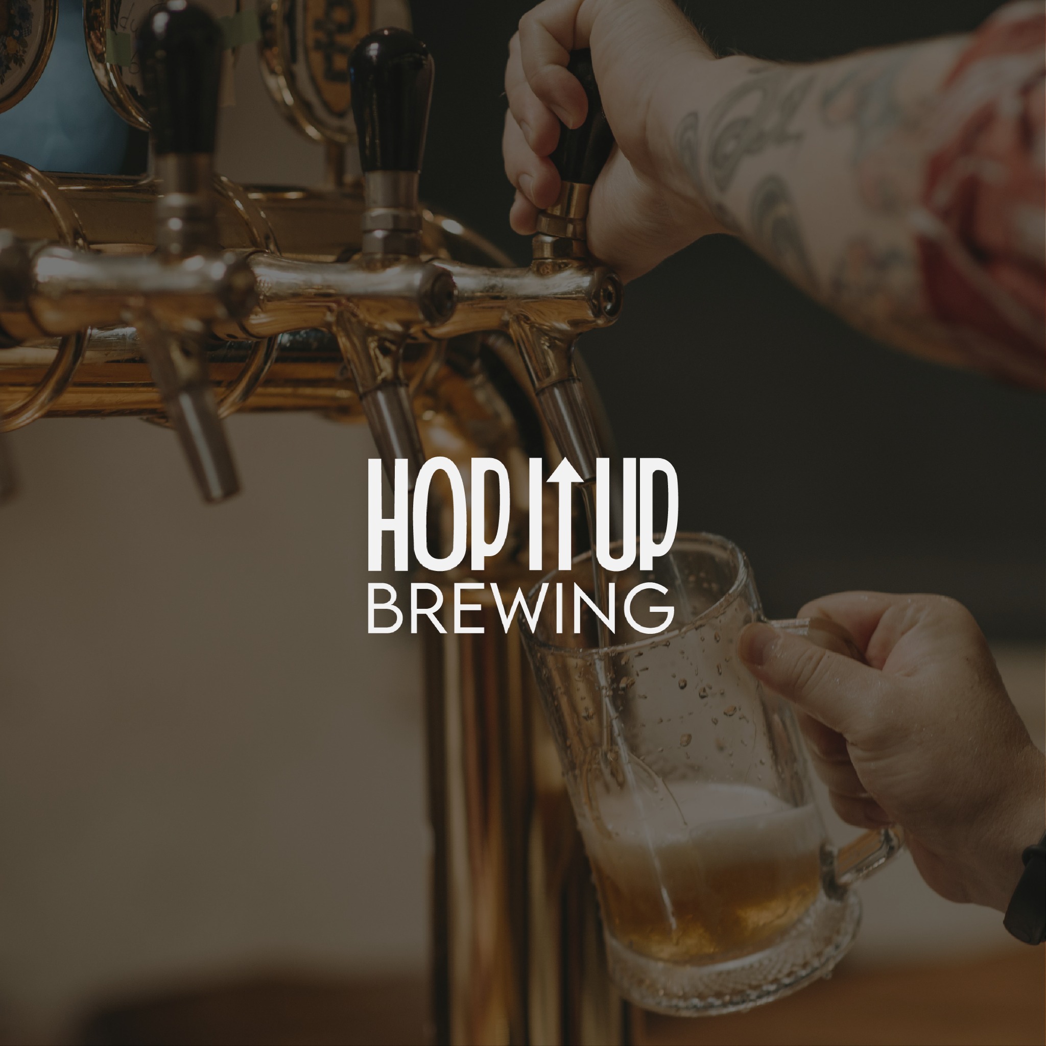 Nalewanie piwa do szklanego kufla z kranu, widoczna wytatuowana ręka.