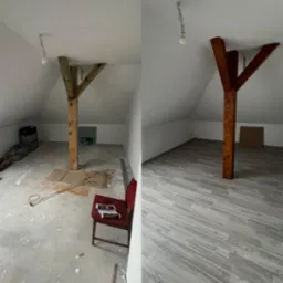 Porównanie stanu poddasza przed i po: surowy beton i drewniany słup kontra panele podłogowe imitujące drewno i lakierowany słup. Czerwone krzesło z dokumentami na poddaszu przed położeniem paneli.