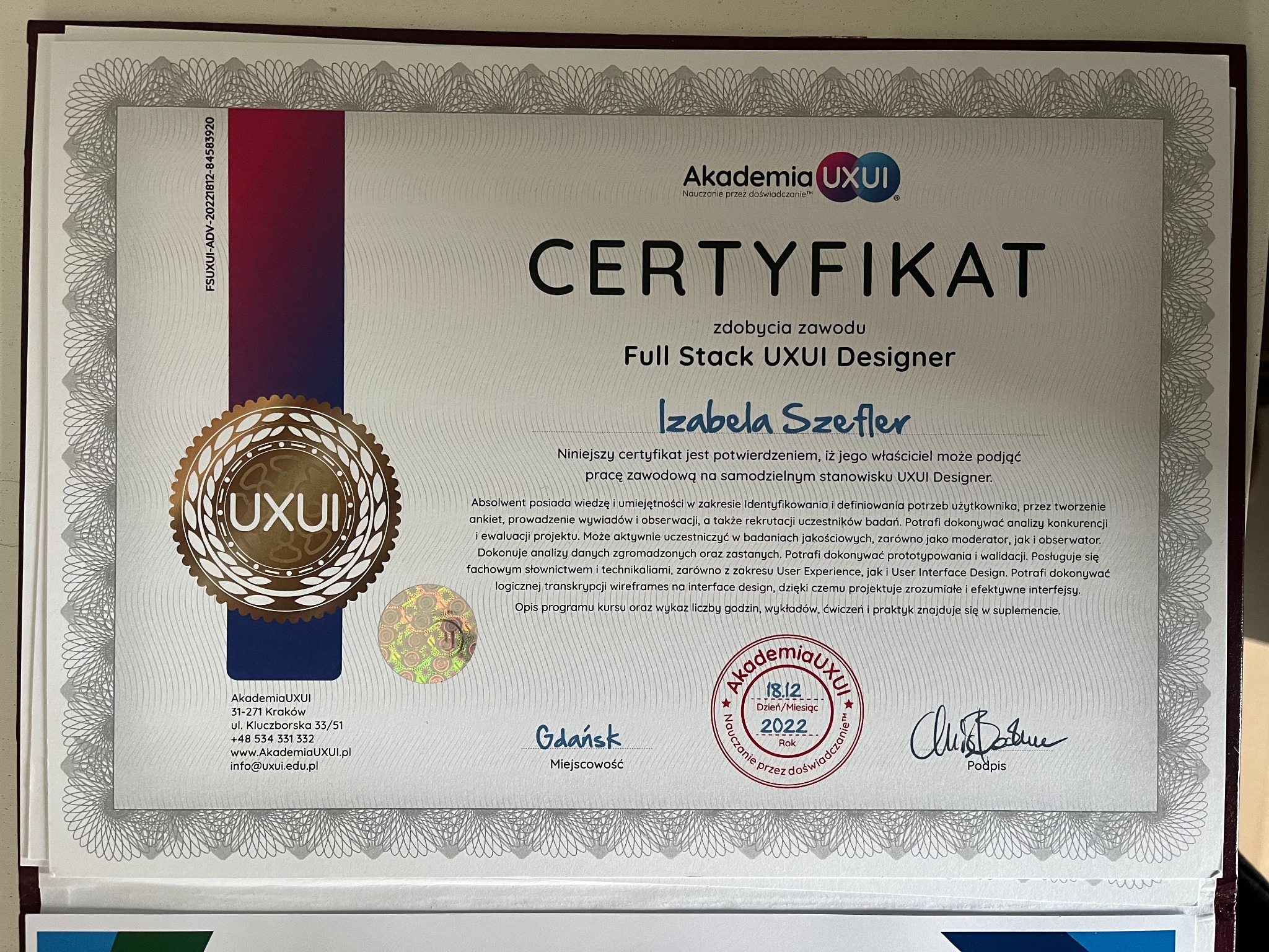 Certyfikat ukończenia kursu Full Stack UXUI Designer wydany przez Akademię UXUI dla Izabeli Szefler. Dokument oprawiony w ramkę, z hologramem i podpisem, potwierdzający wiedzę i umiejętności...