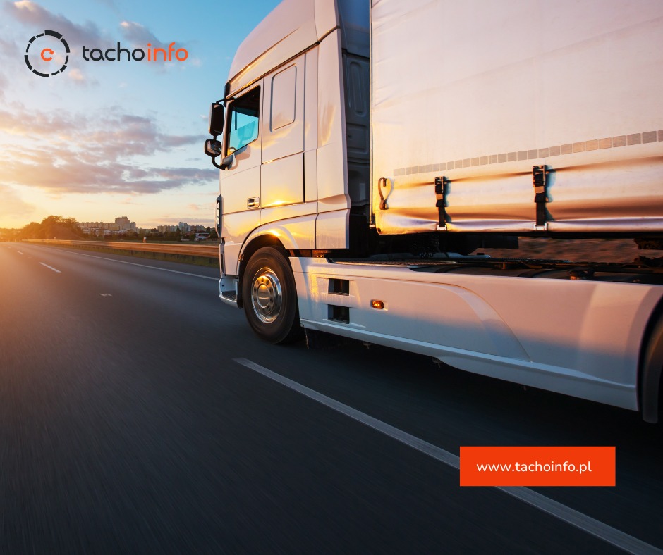 Biała ciężarówka w ruchu na autostradzie w okolicach Rumi, oświetlona promieniami zachodzącego słońca, z widocznym logo firmy na górze.