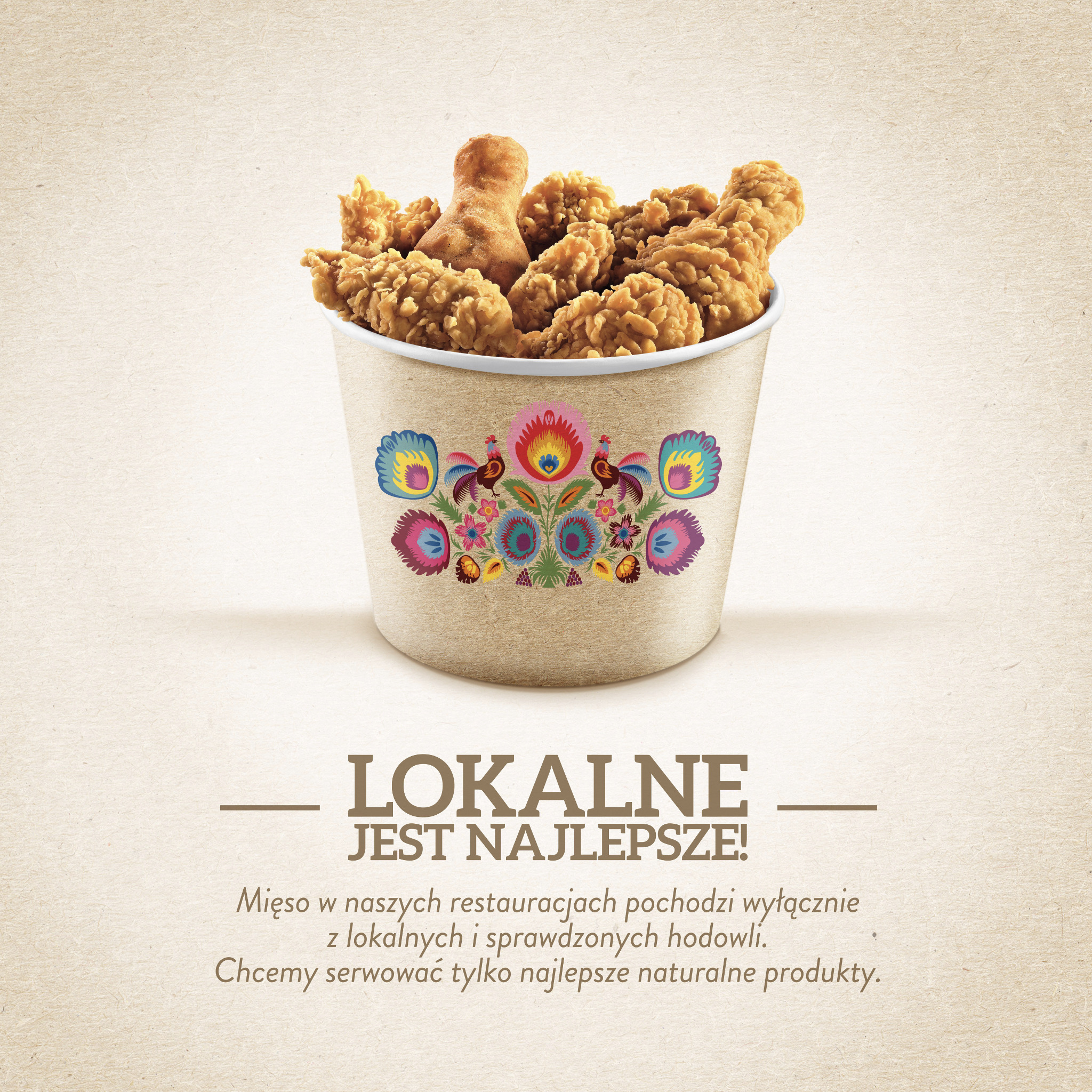 Kubełek z kurczakiem KFC ozdobiony motywami ludowymi, hasło 'Lokalne jest najlepsze!'