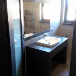 Nowoczesna łazienka z umywalką nablatową na czarnym, kafelkowym postumencie, widok na lustro z dekoracyjnym paskiem mozaiki, grzejnik drabinkowy i okno z naturalnym światłem.