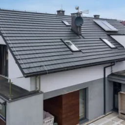 Nowoczesny dom w Szczecinie z grafitowym dachem z dachówki ceramicznej, oknami dachowymi, anteną satelitarną i panelami słonecznymi, widok z góry.