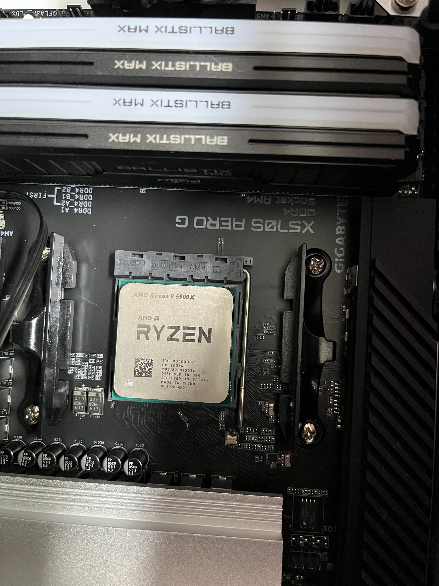 Procesor AMD Ryzen 9 5900X zainstalowany w gnieździe Socket AM4 na płycie głównej Gigabyte X570S AERO G, widoczne moduły pamięci RAM Ballistix MAX.