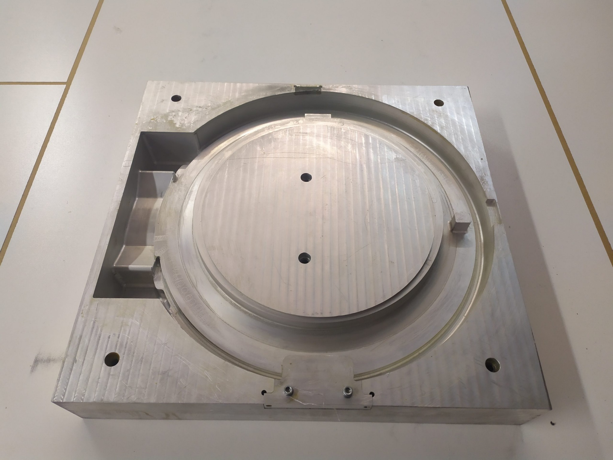 Aluminiowa forma z wyfrezowanymi okrągłymi i prostokątnymi zagłębieniami, wykonana w Łodzi, widoczna z góry na jasnym tle.