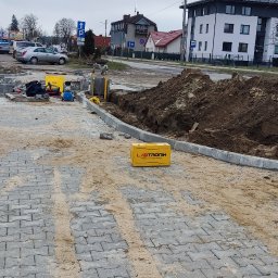 Marek kalkowski Instalator - Prace ziemne i przygotowanie terenu pod instalację przyłącza, widoczny wykop, kostka brukowa, sprzęt do spawania gazowego oraz żółta skrzynka narzędziowa firmy Labtronik.