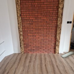 WULK-BUD - Ściana z cegły klinkierowej z drewnianą ramą i panelami podłogowymi w Cisiecu. Dekoracyjne wykończenie wnętrza z rustykalnymi elementami.