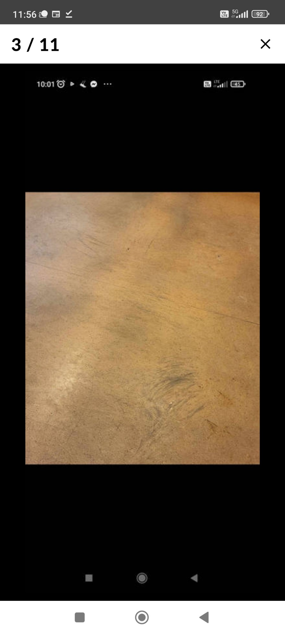 Widok z góry na brązową, matową podłogę z widocznymi smugami i śladami czyszczenia.