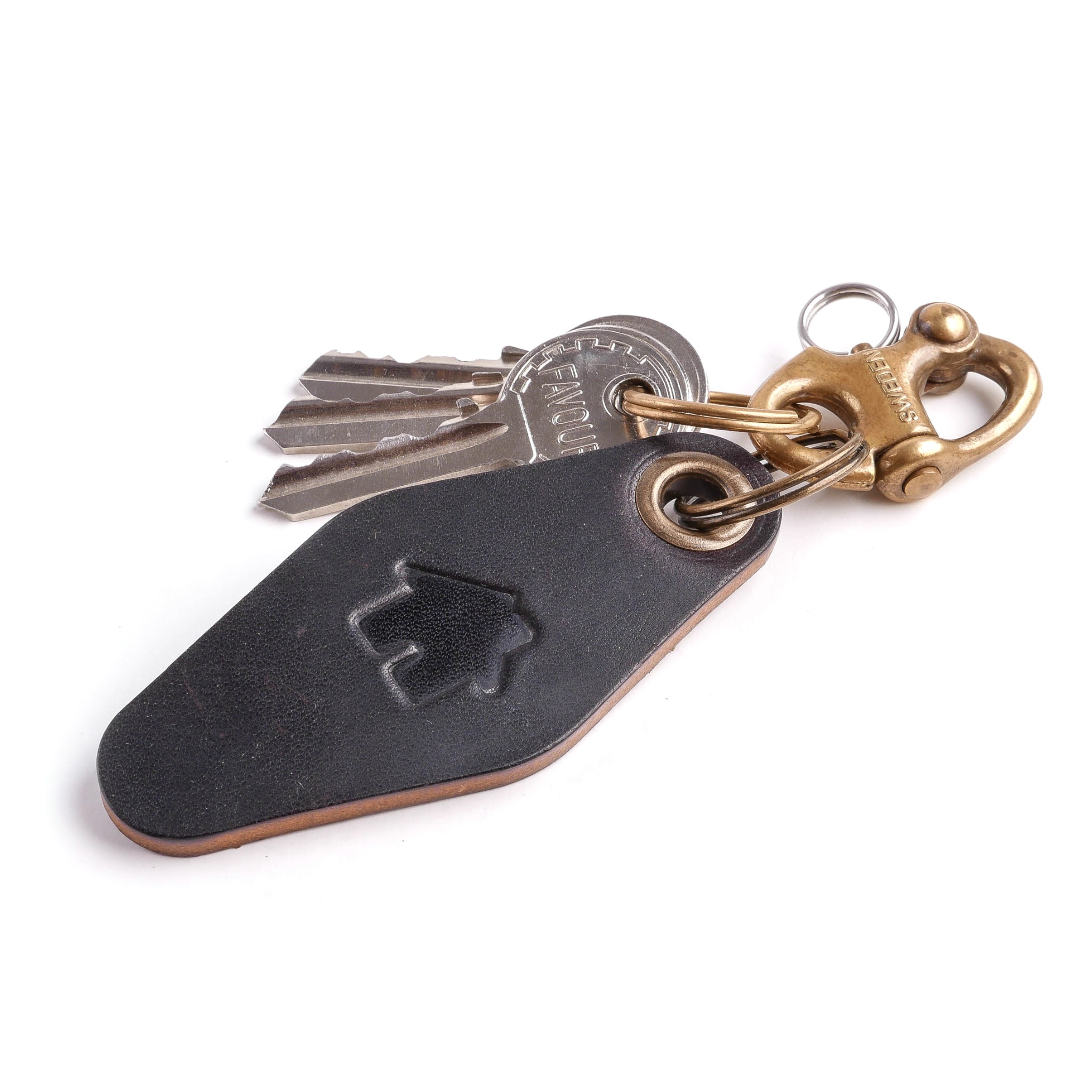 Czarny, skórzany brelok do kluczy z wytłoczonym symbolem domu, przymocowany do trzech kluczy i mosiężnego karabińczyka na białym tle.