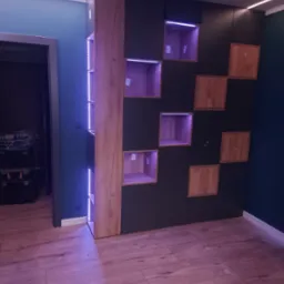 Nowoczesna szafa wnękowa z ciemnymi frontami i drewnianymi akcentami, podświetlane p&oacute;łki, drewniana podłoga, widok z dołu.