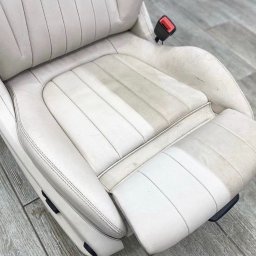 ProfClean - Biały, skórzany fotel samochodowy z widocznymi plamami i różnicą w czystości po częściowym czyszczeniu, ukazujący efekt odświeżenia tapicerki.