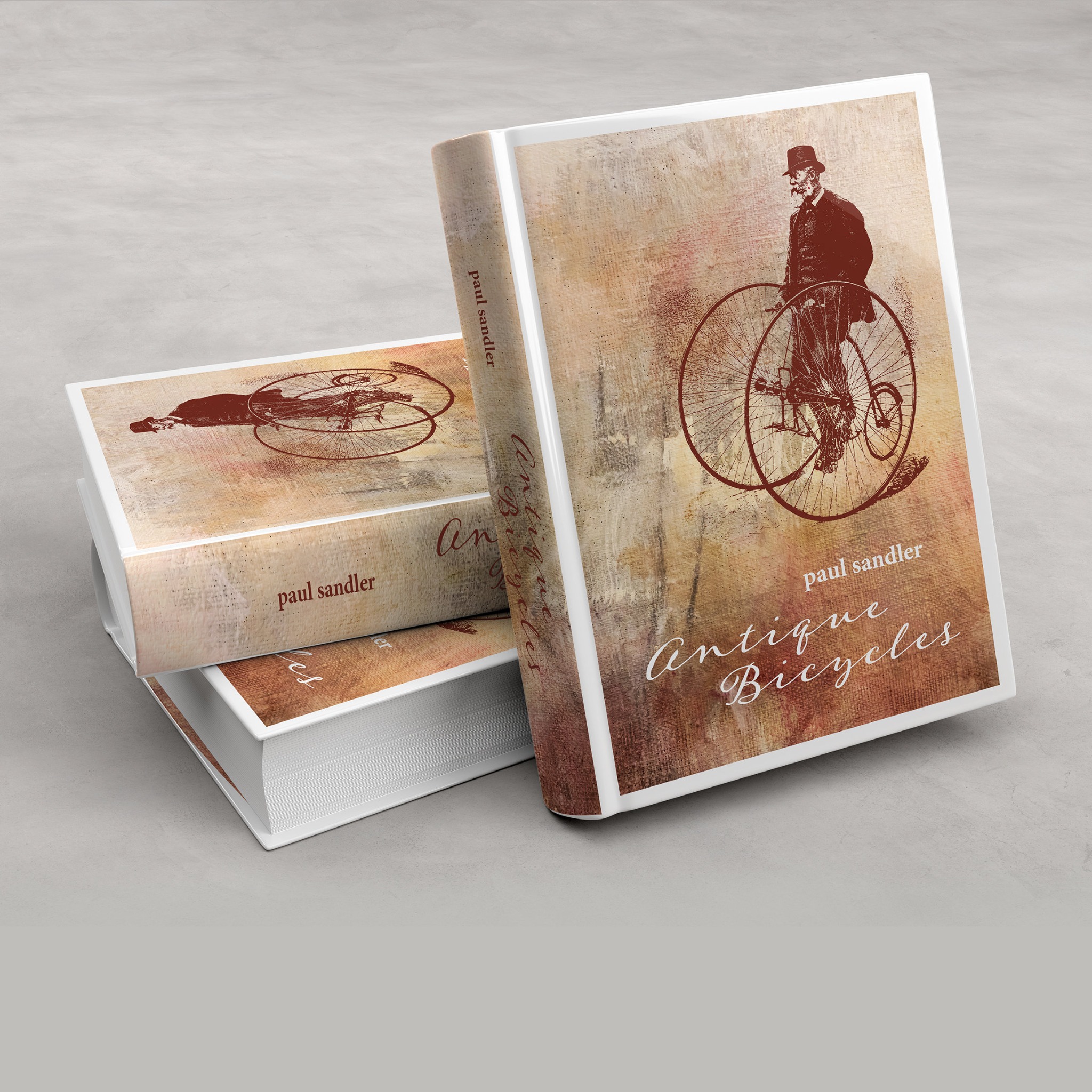 Stos trzech książek w twardej oprawie z ilustracją mężczyzny na wysokim rowerze i tytułem 'Antique Bicycles' Paula Sandlera.