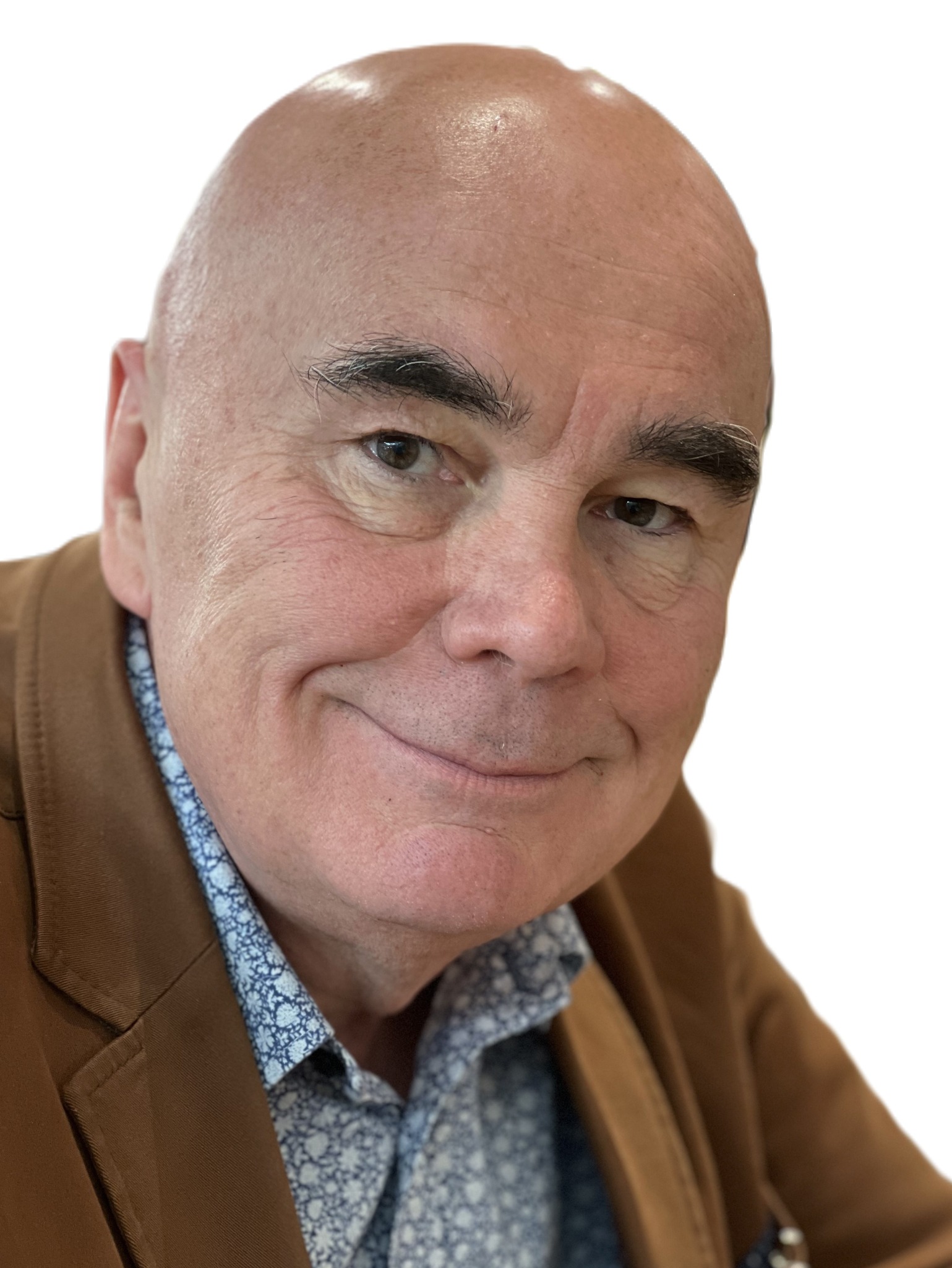 Portret uśmiechniętego mężczyzny w brązowej marynarce i wzorzystej koszuli na białym tle. Widoczne zmarszczki i charakterystyczne brwi.