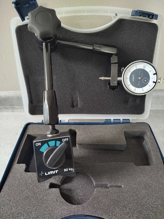 Miernik do pomiaru bicia piast i tarcz Limit 80 kg w otwartym futerale z pianki, widoczny włącznik i wskazówka na tarczy pomiarowej.