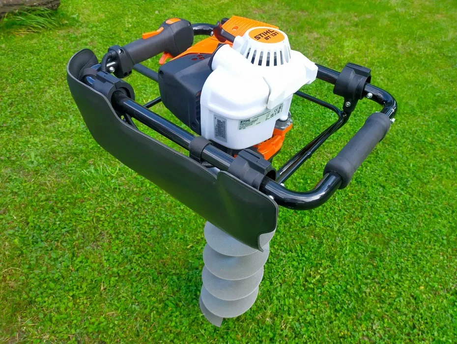Wiertnica glebowa Stihl BT 131 na tle zielonej trawy, widok z góry.