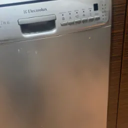 Frontalny widok srebrnej zmywarki Electrolux ESF 45010 S z widocznymi panelami sterowania i drobnymi zabrudzeniami na obudowie.