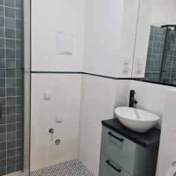 VADYM NIKOLAIEV UBR - Nowoczesna łazienka po remoncie: kabina prysznicowa z ciemną glazurą, białe płytki, umywalka nablatowa na szafce w kolorze morskim i wzorzysta podłoga.