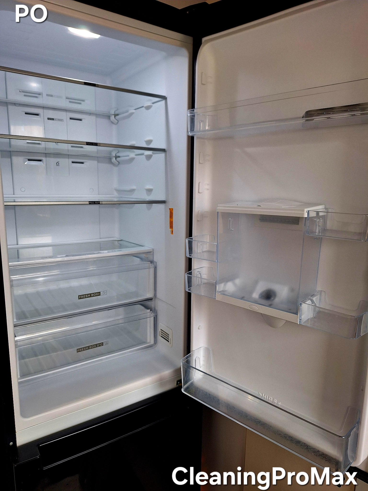 Wnętrze czystej, pustej lodówki z otwartymi drzwiami, z widocznymi półkami i szufladami z przezroczystego plastiku, oświetlone jasnym światłem wewnętrznym.