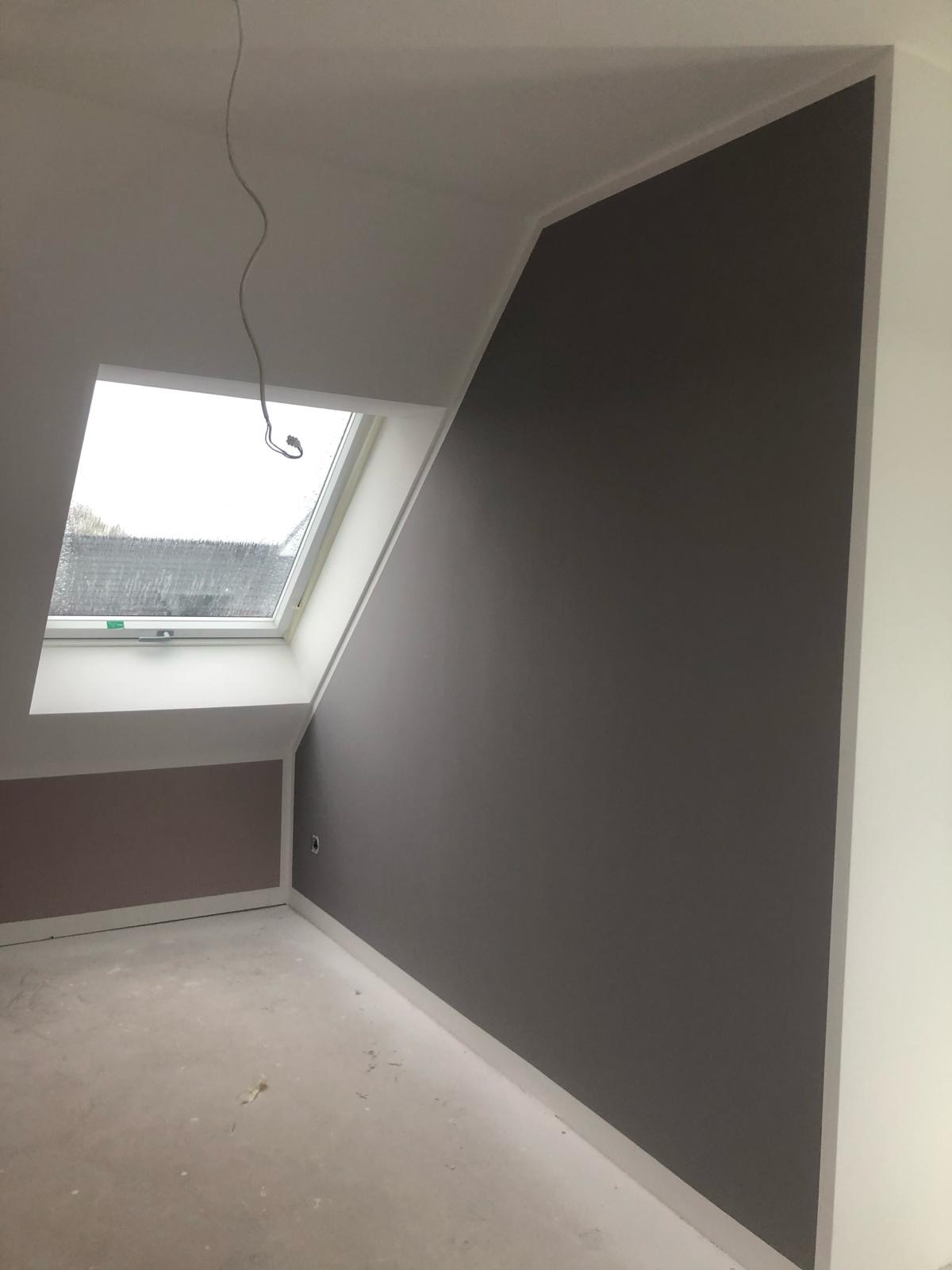 Pokój na poddaszu po szpachlowaniu i malowaniu ścian na szaro, widoczne okno dachowe i przygotowana podłoga.