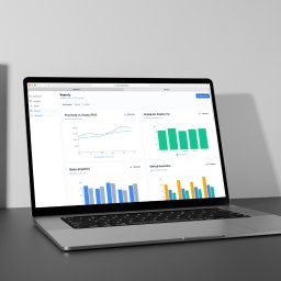 SOCIALBUZZSTUDIO Sp. z o.o. - Laptop wyświetla interfejs analizy danych z wykresami przychodów, kosztów, wydajności działów i statusu projektów. Nowoczesny design, stonowana kolorystyka.