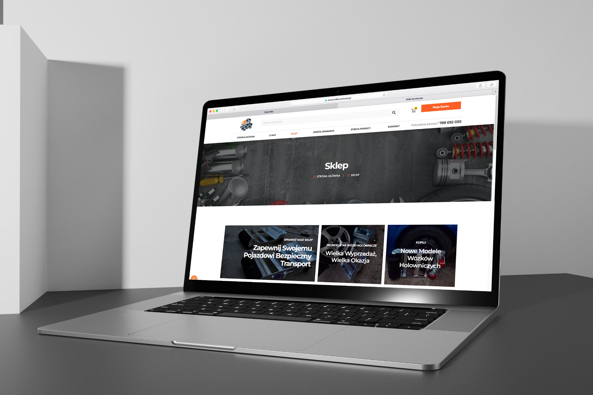 Laptop prezentuje stronę sklepu internetowego z częściami samochodowymi. Widoczny układ strony, nawigacja i oferta. Stonowana kolorystyka, nowoczesny design.