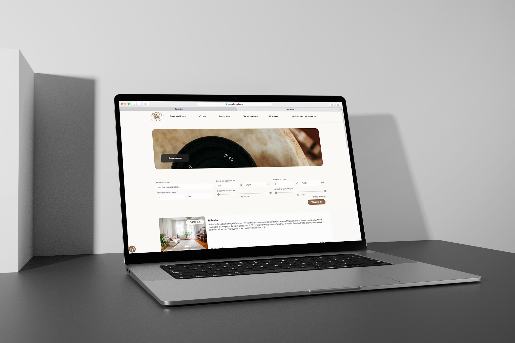 Laptop wyświetla stronę internetową Photo Place z listą miejsc do wynajęcia, z filtrami wyszukiwania i informacjami o studiu fotograficznym leParis.