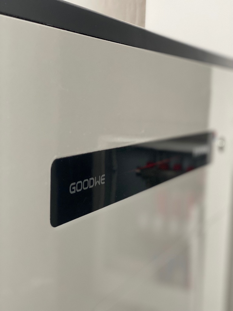 Biała obudowa urządzenia z czarnym panelem i napisem GOODWE, prawdopodobnie falownik, zamontowany w Lublinie.