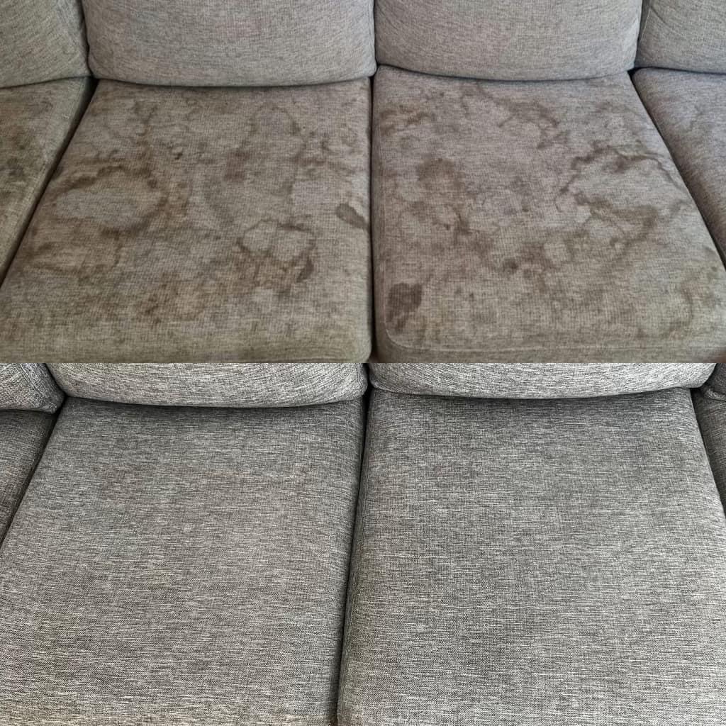 Szara sofa z widocznymi plamami na dwóch poduszkach siedziska, kontrastująca z czystymi, dolnymi poduszkami.