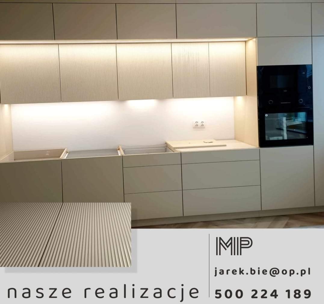 Montaż jasnej zabudowy kuchennej z ryflowanymi frontami szafek górnych i dolnych, z oświetleniem LED podszafkowym i wbudowanym piekarnikiem, częściowo bez blatu.
