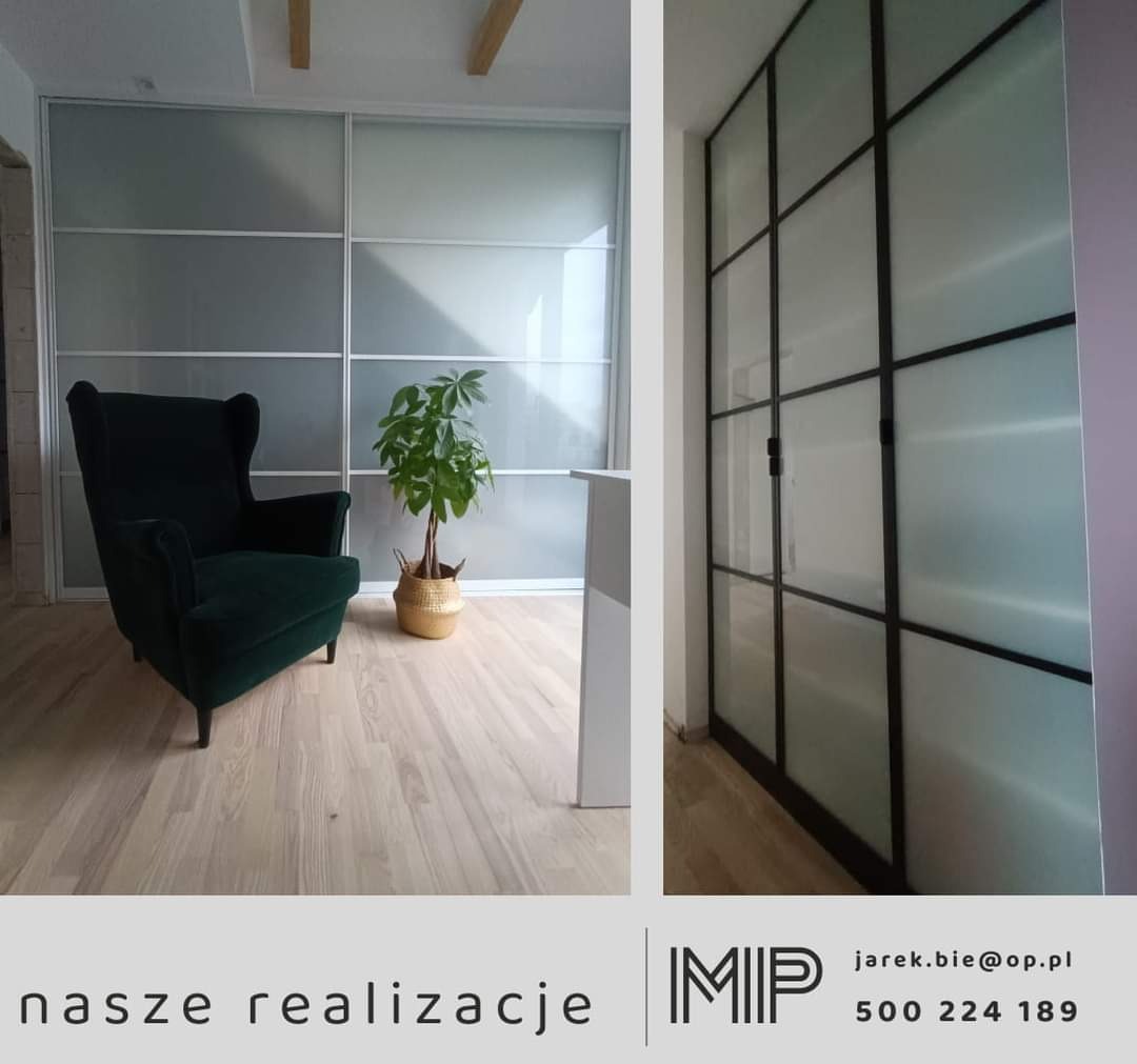 Nowoczesna szafa wnękowa z przesuwnymi drzwiami z matowego szkła i czarnymi szprosami, uzupełniona ciemnozielonym fotelem typu uszak i rośliną w plecionym koszu.