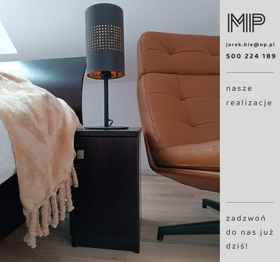 Szafka nocna z ciemnego drewna, lampka nocna z perforowanym abażurem, fragment łóżka z beżowym pledem i brązowy fotel na obrotowej podstawie.