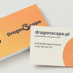 Stos wizytówek z logo smoka w odcieniach pomarańczy i granatu, jedna wizytówka z danymi kontaktowymi na wierzchu, na białym tle.