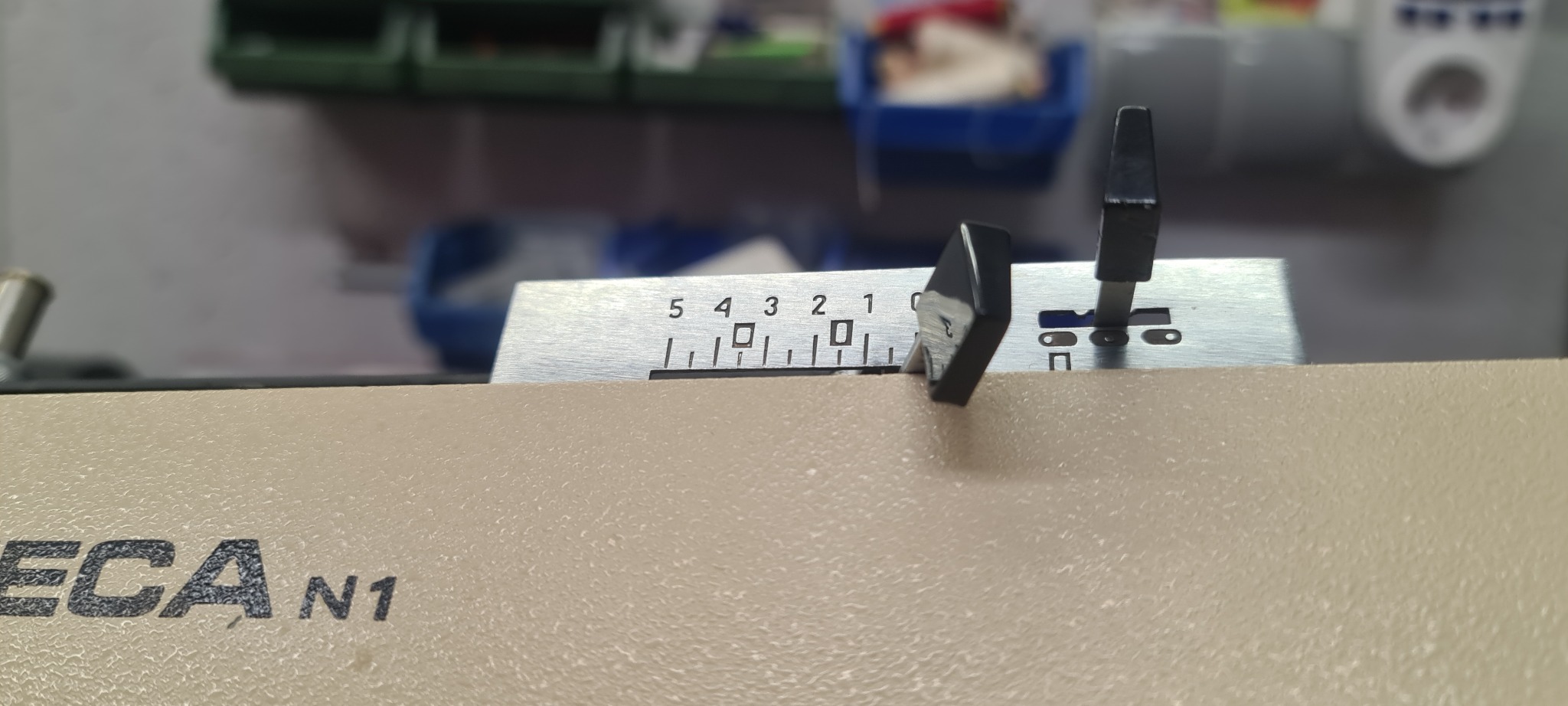 Bliski kadr fragmentu maszyny z suwakiem ustawionym na wartości 3, widoczny napis ECA N1, tło z pojemnikami.
