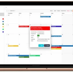 Ekran laptopa wyświetlający kalendarz z zaznaczonymi zadaniami i spotkaniami w usłudze TaskManagement24.com, z otwartym oknem szczegółów spotkania z klientem.