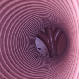 HYDRAULIK Tomasz Krebs - Wnętrze karbowanej rury kanalizacyjnej z trójnikiem z tworzywa sztucznego. Widok z perspektywy wnętrza rury, ukazujący połączenie.