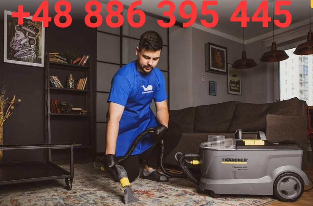 Mężczyzna w niebieskim fartuchu i czarnych rękawicach czyści dywan za pomocą odkurzacza piorącego Kärcher Professional Puzzi 400. W tle widoczny salon z szarą kanapą i regałem na książki.