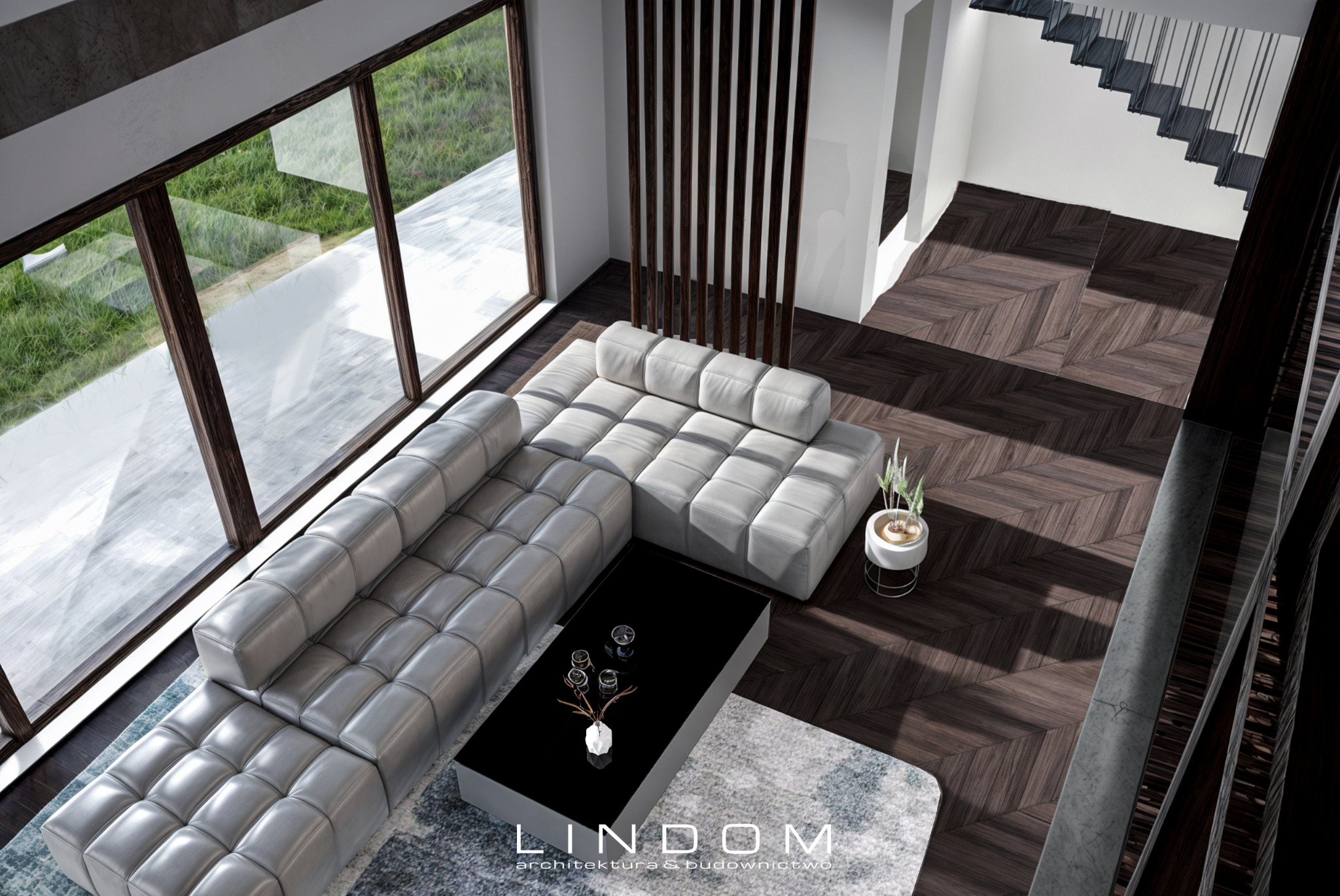 Wnętrze domu z widokiem z góry: duży narożnik w jasnej tonacji, czarny stolik kawowy z dekoracjami, parkiet ułożony w jodełkę, schody w tle, duże okno z widokiem na zieleń, dekoracyjna ścianka...