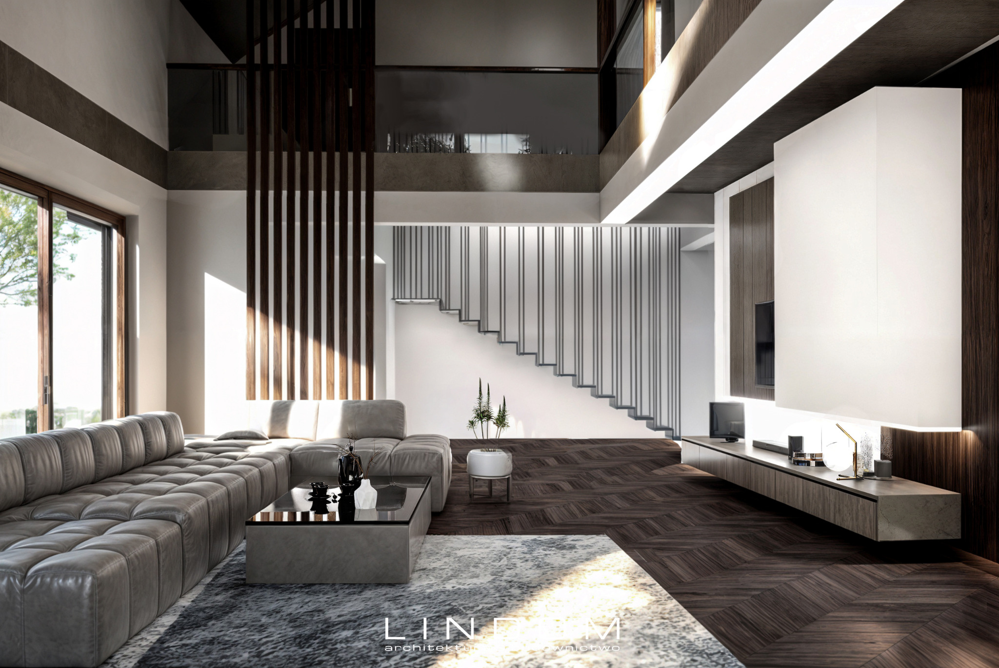 Przestronne wnętrze salonu z antresolą w domu jednorodzinnym w Czyżowicach, z widoczną dużą sofą, szklanym stolikiem kawowym, schodami z metalowymi barierkami i drewnianą podłogą ułożoną w jodełkę.