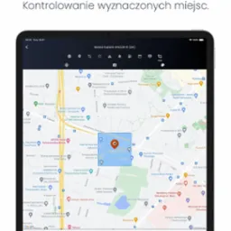 Aplikacja na tablecie prezentuje mapę z zaznaczoną geostrefą, wskazującą obszar kontrolowany przez system monitoringu pojazdów, z widocznymi nazwami punktów orientacyjnych i ulic.