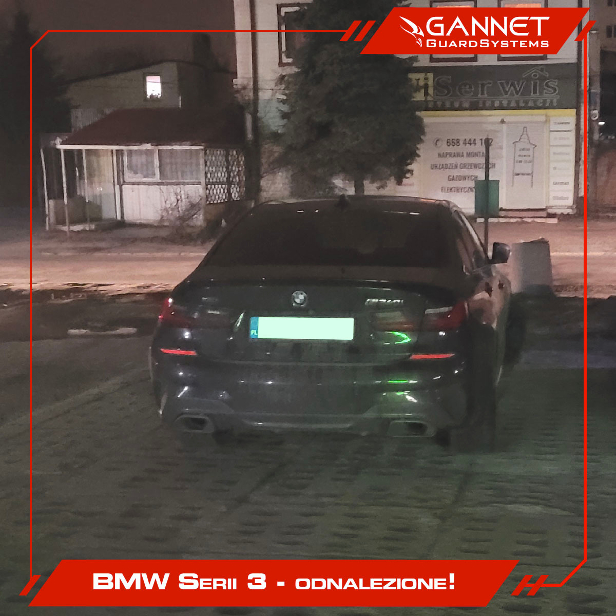 Odnaleziony czarny samochód BMW Serii 3 zaparkowany nocą na tle budynku z napisem Serwis, co sugeruje użycie systemu monitoringu GPS do lokalizacji pojazdu.