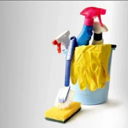Niebieskie wiadro z ż&oacute;łtymi rękawicami, butelkami ze spryskiwaczem, szczotką i gąbką na szarym tle. Zestaw do sprzątania.