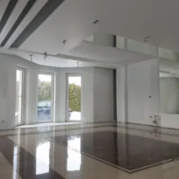 Przestronne, jasne wnętrze w trakcie wykańczania: białe ściany, błyszcząca podłoga z płytek w geometryczny wz&oacute;r, sufit z dekoracyjnymi, szarymi belkami i lustrami, widoczne kable wystające z sufitu...