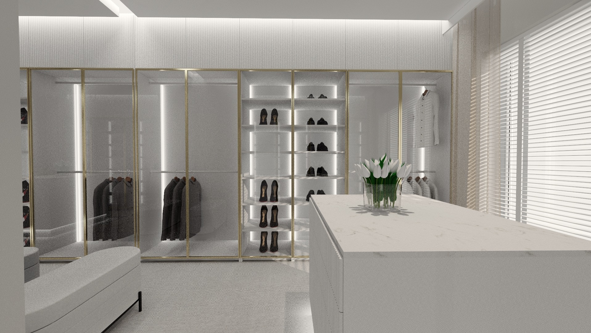 Nowoczesna garderoba z przeszklonymi szafami, złotymi ramami i wyspą z blatem marmurowym, uzupełniona białymi tulipanami i żaluzjami.