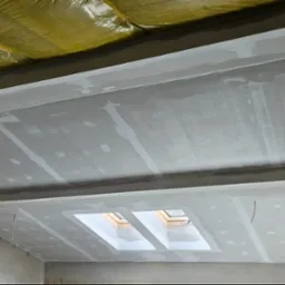 Sufit podwieszany z zamontowaną izolacją i oknem dachowym, wstępnie wyszpachlowany, widoczne łączenia płyt