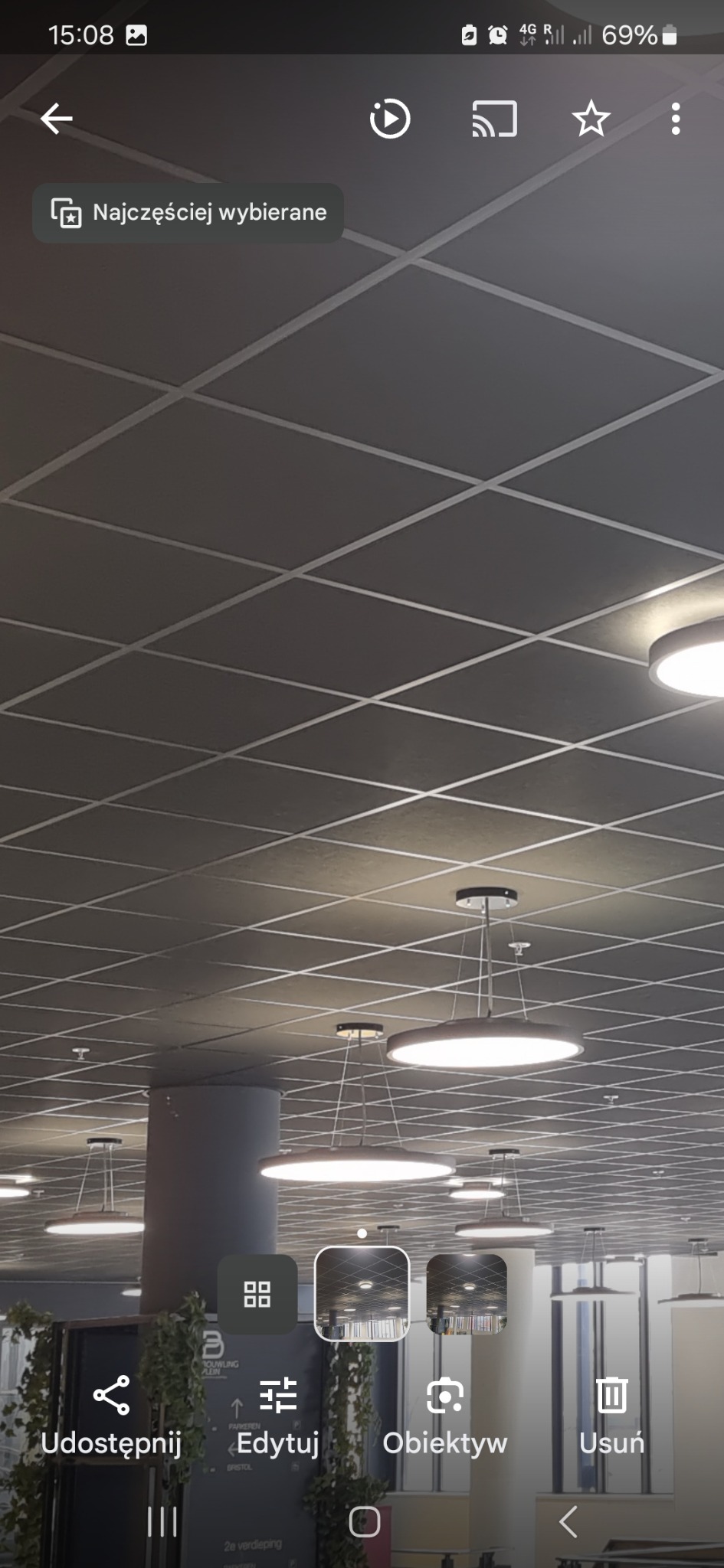 Sufit kasetonowy w biurze z okrągłymi lampami wiszącymi, widok z dołu, szara kolorystyka.