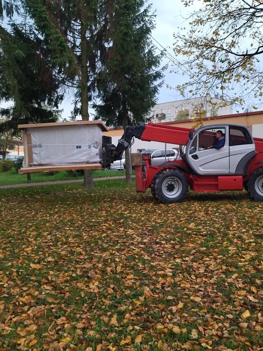Podanie ładowarką teleskopową przez okno urządzenia medycznego