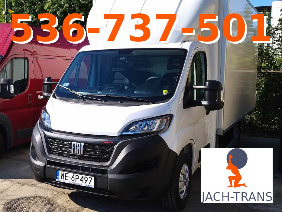 Biały samochód dostawczy Fiat Ducato z zabudową kontenerową, widoczny numer telefonu i logo firmy JACH-TRANS, obok zaparkowany czerwony bus.