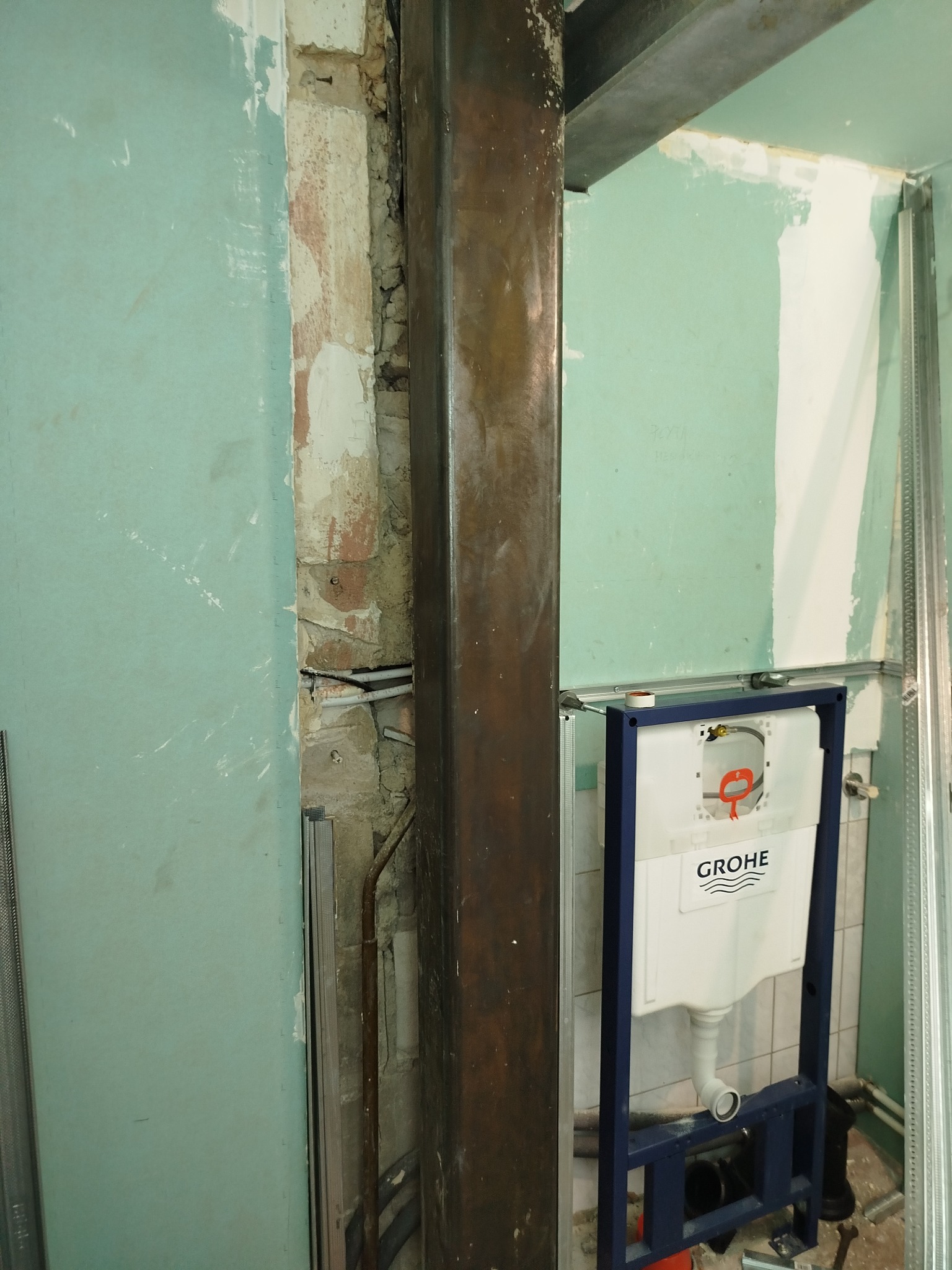 Montaż stelaża podtynkowego WC Grohe w trakcie prac wykończeniowych łazienki. Widoczne płyty gipsowo-kartonowe i metalowe profile konstrukcyjne.