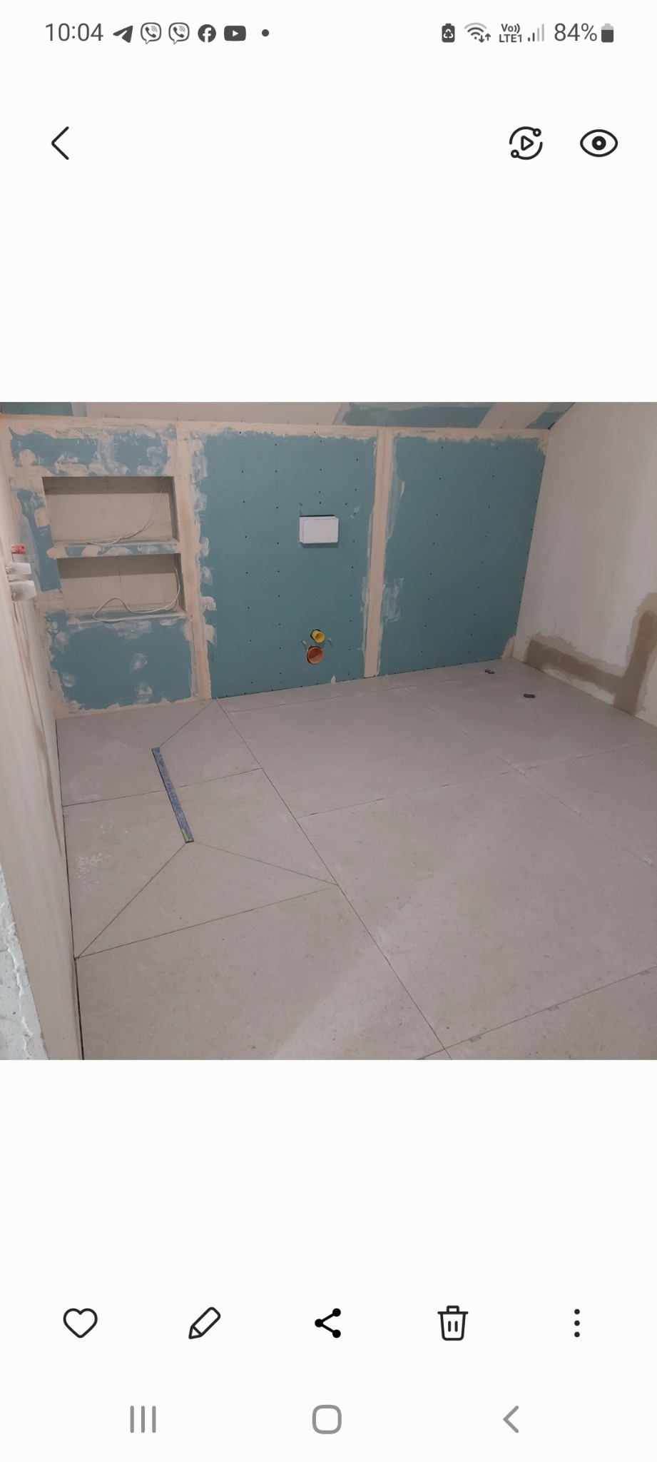 Wnętrze w trakcie prac wykończeniowych: położone płytki podłogowe, ściany z płyt kartonowo-gipsowych przygotowane do dalszych prac, widoczne instalacje.